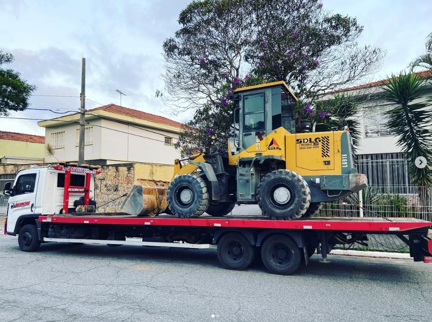 Guincho plataforma transportando máquina pesada
